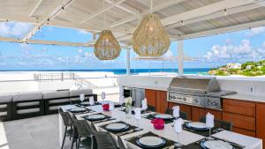 a dining room with a table and a kitchen at Tranquility Beach Anguilla Resort in Meads Bay