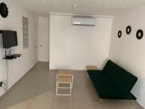 a room with a green couch and a chair at Marina Diamante - Ilse C in Acapulco
