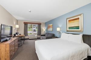 a hotel room with a bed and a tv at The Commerce, Trademark Collection by Wyndham in River Falls