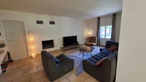 a living room with a couch and chairs and a table at Ginette et Marcel la maison in Saint-Rémy-de-Provence