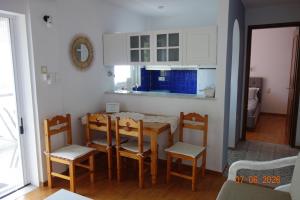a kitchen and dining room with a table and chairs at Irini Seaside Apartment in Paleo Tsifliki +26 photos