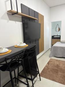 a room with a table and chairs and a bed at Loft Vip RR in Boa Vista