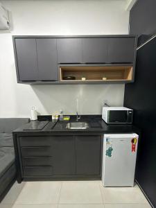 a small kitchen with a sink and a refrigerator at Loft Vip RR in Boa Vista