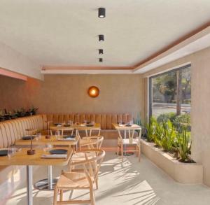 a restaurant with tables and chairs and a large window at Hotel Mome in San Juan