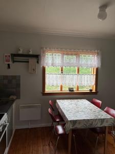 a kitchen with a table and chairs and a window at Grjótá Historical countryhouse in Hvolsvöllur