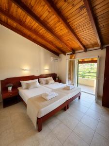 a bedroom with a large bed with a wooden ceiling at Pangea Corfu Villa in Sidari +24 photos