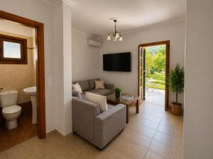 a living room with a couch and a tv at Pangea Corfu Villa in Sidari