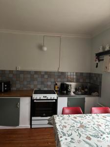 a kitchen with a stove and two red chairs at Grjótá Historical countryhouse in Hvolsvöllur