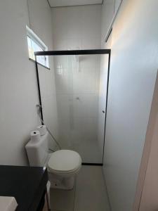 a bathroom with a toilet and a glass shower at Loft Vip RR in Boa Vista