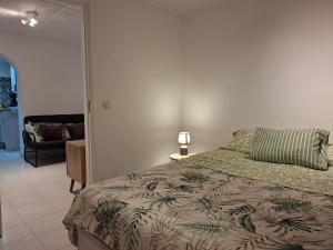 a bedroom with a bed and a lamp and a couch at Casa de Férias Palmeira in Faro