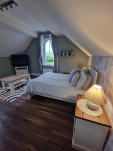 a bedroom with a bed and a table with a lamp at Tully View House in Donegal