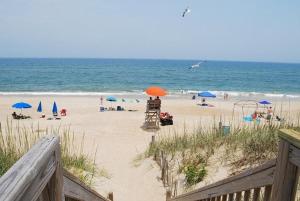 a beach with umbrellas and people on the beach at SW6 - Seawalk 6 in Kill Devil Hills