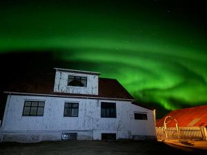 a house with the green northern lights in the sky at Grjótá Historical countryhouse in Hvolsvöllur
