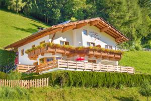 a house with a balcony on a hill at Landhaus Toni in Neustift im Stubaital