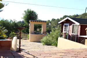 a garden with a small house and a patio at Casa Llorens in Denia
