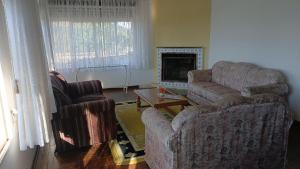 a living room with two chairs and a television at Studio na Serra I in Itatiaia