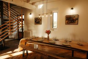 a dining room with a wooden table with flowers on it at Moulin de Micheline - Jacuzzi - Vue Exceptionnelle in Bourg-dʼIré