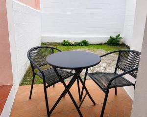 two chairs and a table on a patio at Sons da Ribeira in Ribeira Grande +2 photos