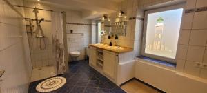 a bathroom with a sink and a shower and a window at Ferienwohnung Küstennah in Großenwiehe +31 photos