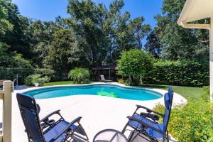 a swimming pool with two chairs and a table at Costal Lane - Main in Jacksonville