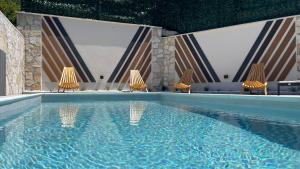 a swimming pool with two chairs and a swimming pool at MO House Mostar in Kutilivač