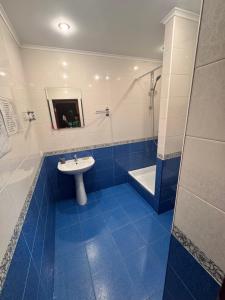 a blue and white bathroom with a sink and a tub at Гостевой дом Надежда in Zatoka +76 photos