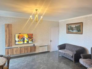 a living room with a couch and a chandelier at kobuleti Apartment in Kobuleti
