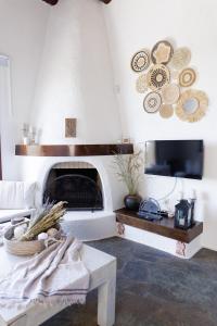 a living room with a fireplace and a tv at Pasithea Sunset in Milopótamos