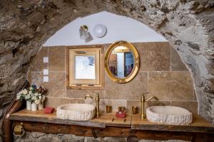 two sinks in a stone bathroom with a mirror at Une demeure d'exception au cœur des Alpes du Sud in Venterol +29 photos