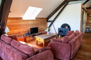 a living room with two couches and a tv at Une demeure d'exception au cœur des Alpes du Sud in Venterol