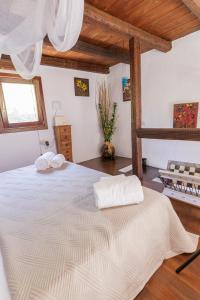 a bedroom with a bed with two towels on it at Pasithea Sunset in Milopótamos