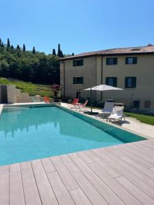 a swimming pool with two chairs and a building at Il Rustico di Corte Palù in San Martino Buon Albergo