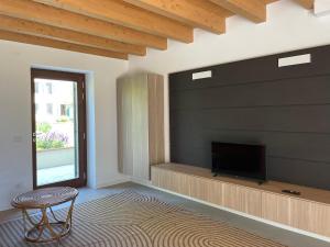 a living room with a tv and a chair at Il Rustico di Corte Palù in San Martino Buon Albergo
