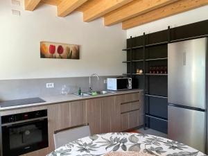a kitchen with a stainless steel refrigerator and a microwave at Il Rustico di Corte Palù in San Martino Buon Albergo