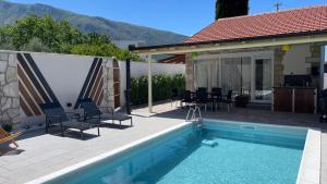 a villa with a swimming pool and a house at MO House Mostar in Kutilivač