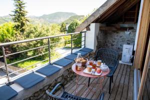 a table and chairs on a balcony with a view at Une demeure d'exception au cœur des Alpes du Sud in Venterol