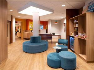 a lobby with two blue stools and a table and chairs at Adagio Access Lyon Centre Université in Lyon +48 photos