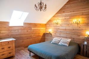 a bedroom with wooden walls and a bed with two pillows at Une demeure d'exception au cœur des Alpes du Sud in Venterol