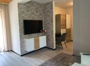 a living room with a brick fireplace with a tv at Appartment im Schwarzwald in Furtwangen