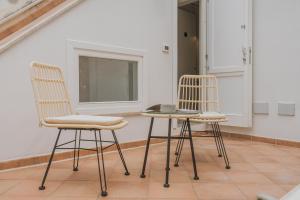 two chairs and a table in a room with a window at Casa Ritunno Rooms in Favignana