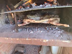 a piece of meat is cooking in an oven at Al pie de la Sierra in Pueblito