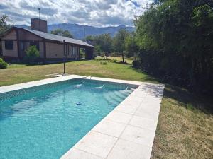 a swimming pool in a yard next to a house at Al pie de la Sierra in Pueblito