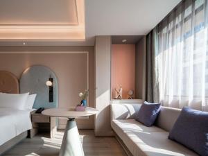 a hotel room with a couch and a table at Mercure Chengdu Wuhou Temple in Chengdu