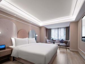 a bedroom with a large white bed and a living room at Mercure Chengdu Wuhou Temple in Chengdu +87 photos