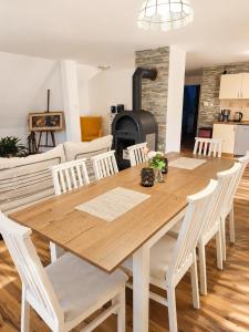 a dining room table with white chairs and a stove at Forest House near Klínovec with 5 Independent Apartments in Kovářská