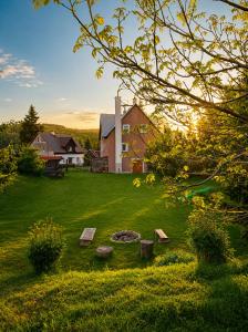 a backyard with a fire pit and a house at Forest House near Klínovec with 5 Independent Apartments in Kovářská