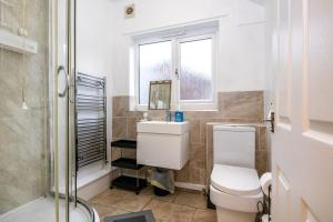 a bathroom with a toilet and a sink and a shower at 2Bd Mid Terrace Close To Station in Stoke on Trent