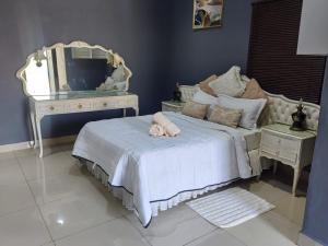 a bedroom with a bed with a mirror and a dresser at Qten Camp in Pietermaritzburg