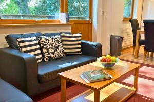a living room with a blue couch and a table at Scandi Style Bracken Lodge with Private Decking Sleeps 6 in Chudleigh Knighton
