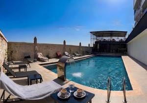 a swimming pool with chairs and a table on a building at Beyaz Kosk in Demre